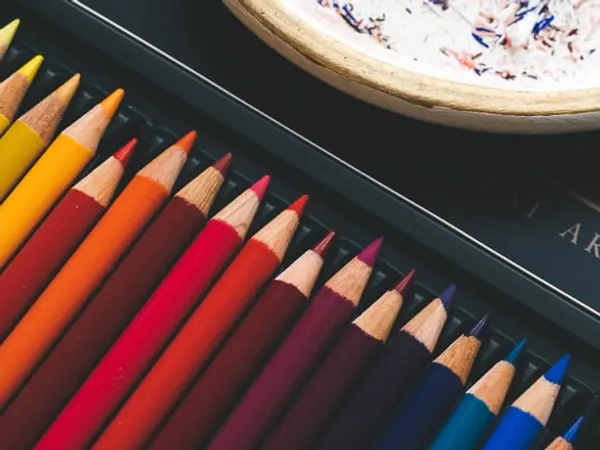 A tin of colored pencils, a paint tube and blending stumps