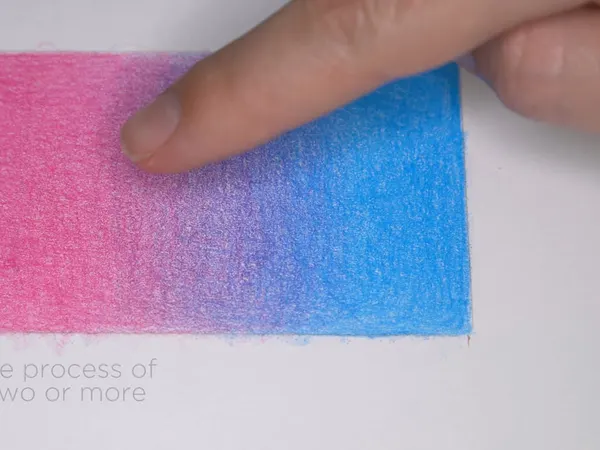 A pink and blue colored pencil swatch being layered