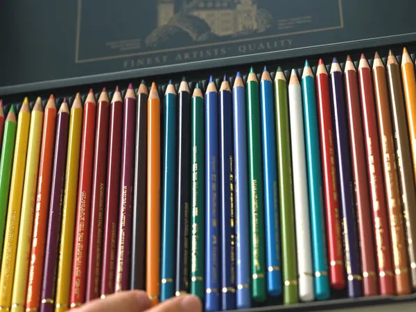 An open tin of colored pencils