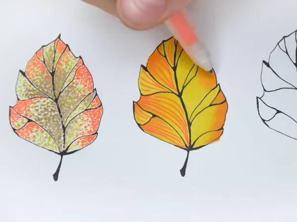 Two autumn leaves decorated with gel pen